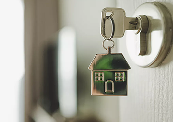 Clé avec porte-clé en forme de maison dans une serrure